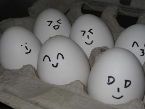 a package of eggs with little faces drawn on them